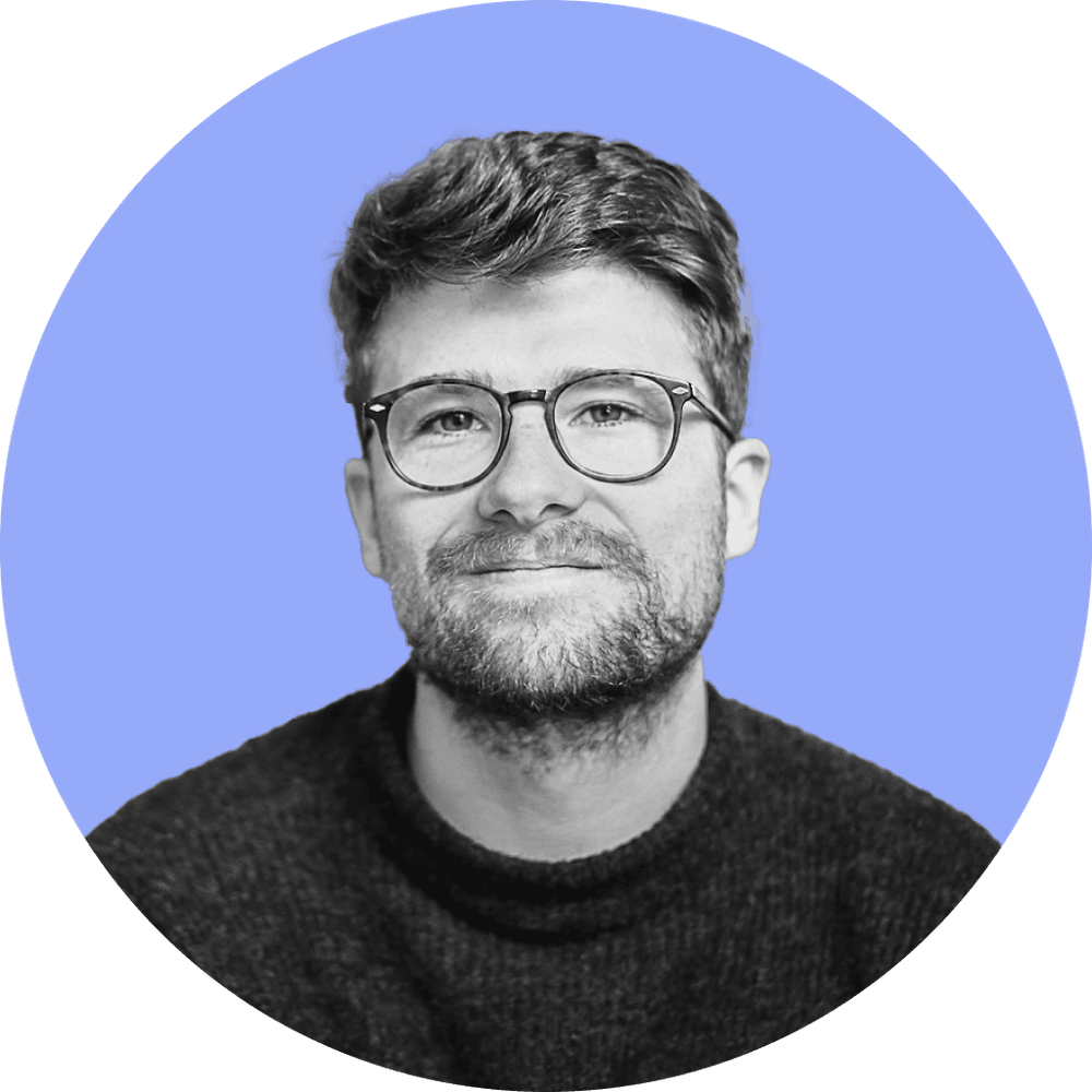 Martin im 3/4 Profil mit Brille und Lächeln.